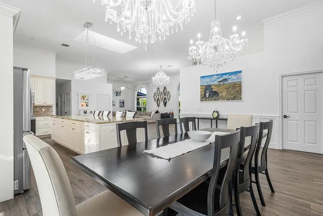 a kitchen with stainless steel appliances granite countertop a kitchen island a stove a table and chairs in it