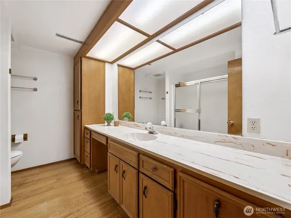 a spacious bathroom with a granite countertop sink mirror and a bathtub