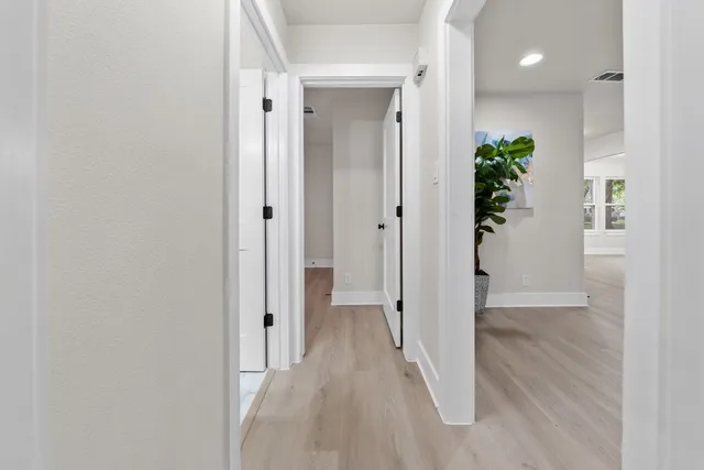 a view of a hallway with wooden floor
