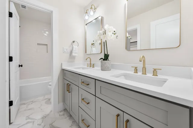 a bathroom with a sink tub vanity and a mirror
