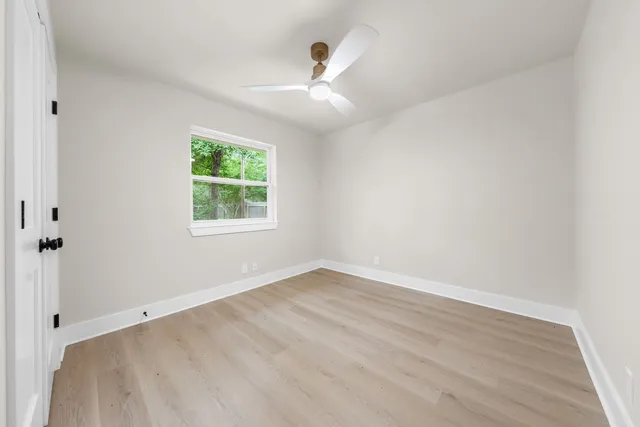 an empty room with window and a ceiling fan
