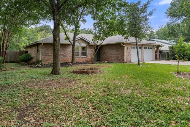 a front view of a house with a yard and trees