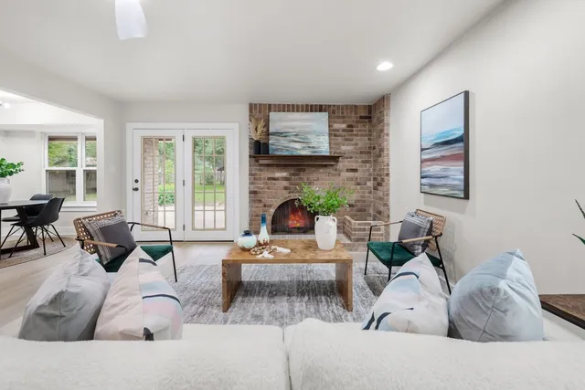a living room with furniture a large window and a fireplace