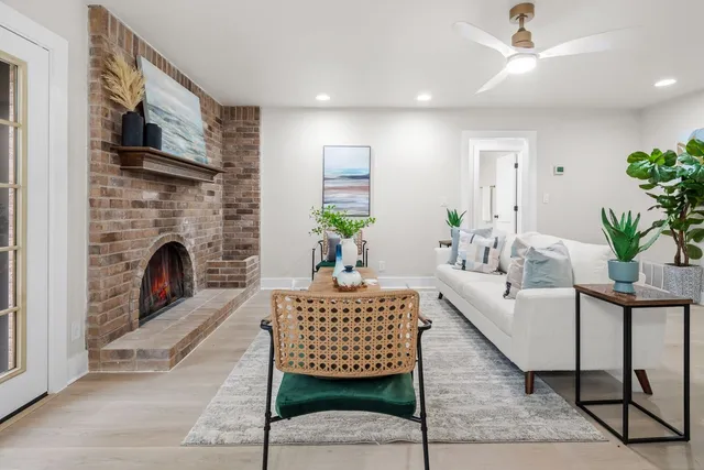 a living room with furniture a fireplace and a potted plant