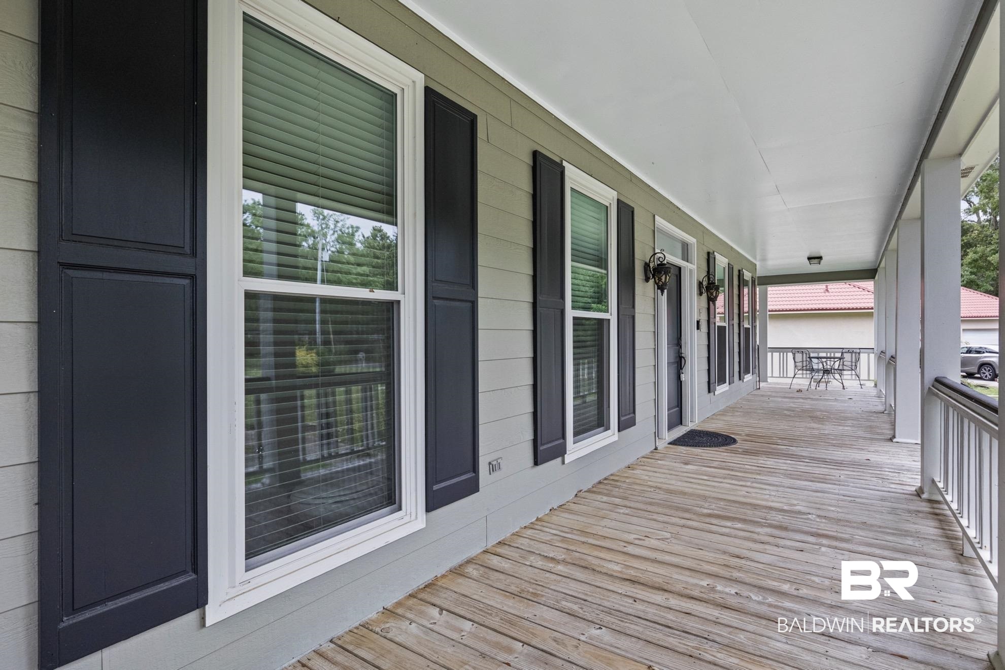 12171 Marguerite Drive Coden, AL 36523 - Photo 25 of 44 Expansive covered porch featuring wood flooring, white railings, and white support columns