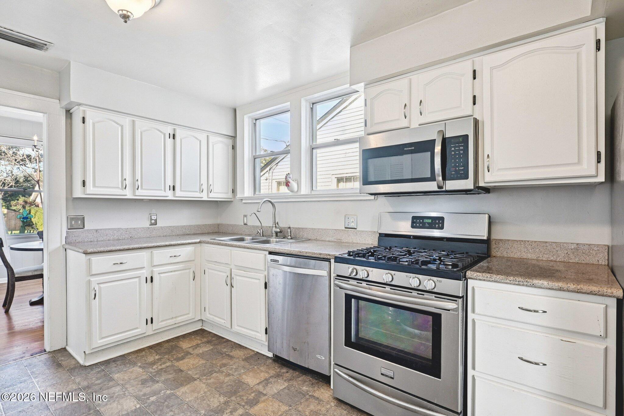 1021 Old Hickory Road Jacksonville, FL 32207 - Photo 18 of 42 a kitchen with granite countertop white cabinets white stainless steel appliances and a sink