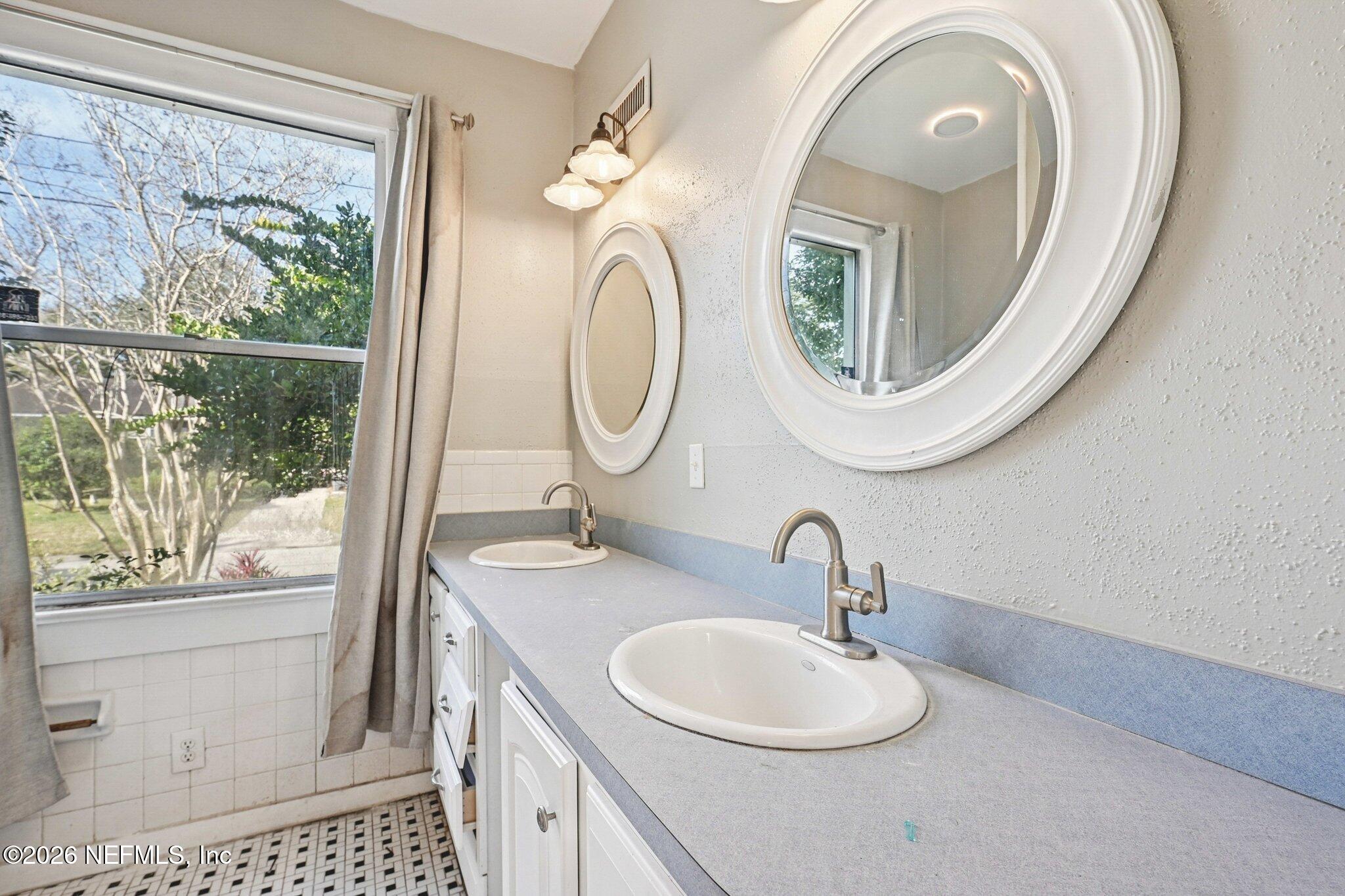 1021 Old Hickory Road Jacksonville, FL 32207 - Photo 27 of 42 a bathroom with a sink a mirror and a shower