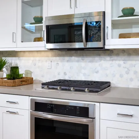 a kitchen with granite countertop a stove and a microwave