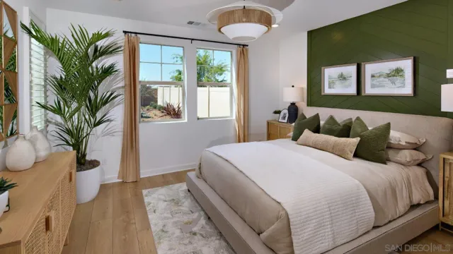 a bedroom with a large bed and a potted plant