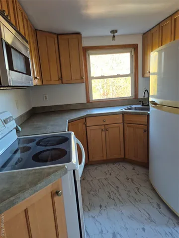 a kitchen with a refrigerator a stove a sink and a window
