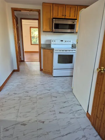 a kitchen with granite countertop a stove a microwave and a sink