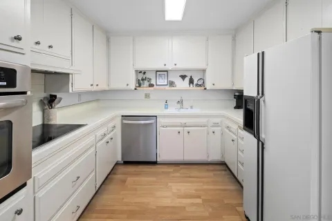 a kitchen with white cabinets and white appliances