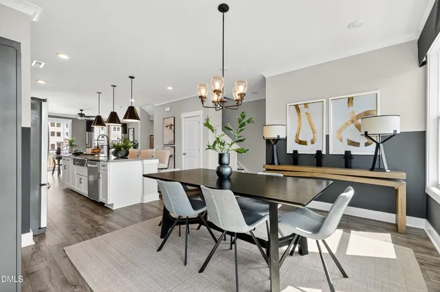 a dining room filled chandelier and kitchen view