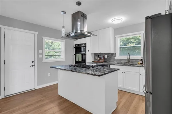 a kitchen with stainless steel appliances granite countertop a stove a sink and a refrigerator