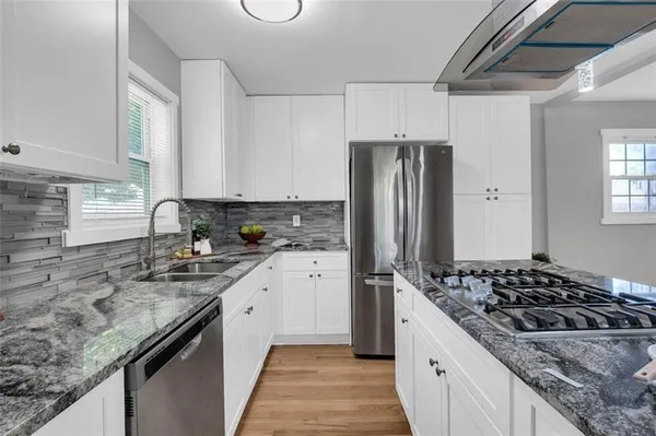 a kitchen with refrigerator stove and sink