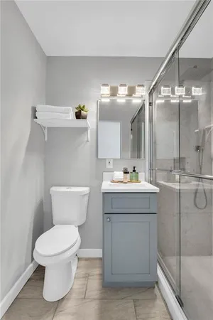 a bathroom with a sink mirror toilet and shower