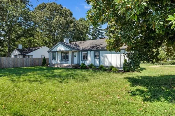 a view of a house with a yard and sitting area