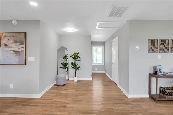 a view of a hallway to a livingroom with furniture