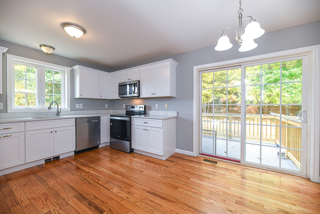 20 Shawnee Road, Unit A Pepperell, MA 01463 - Photo 3 of 35 a kitchen with a window wooden cabinets and a sink