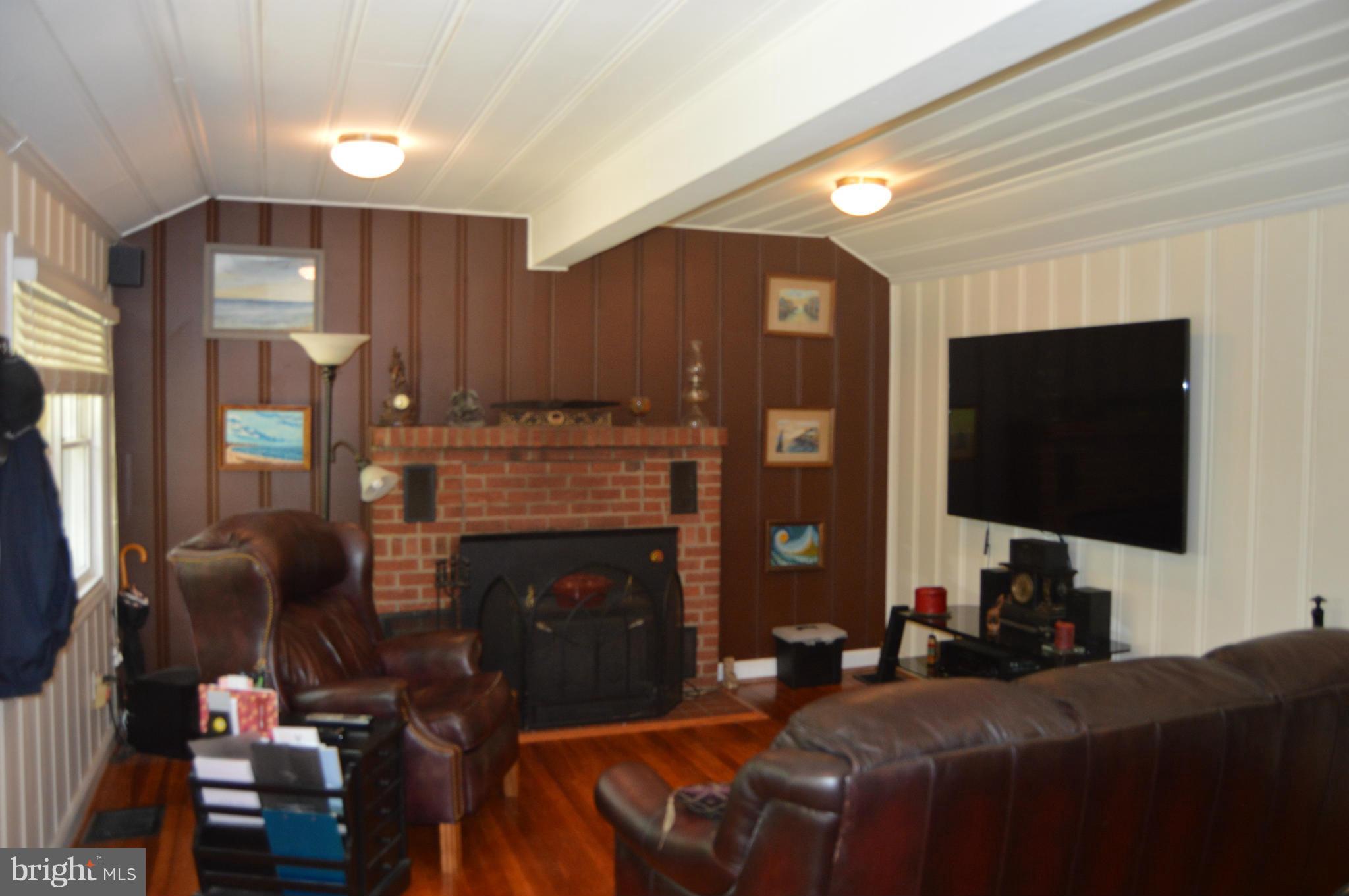 355 Ridge Road Pasadena, MD 21122 - Photo 14 of 22 a living room with furniture a fireplace and a flat screen tv