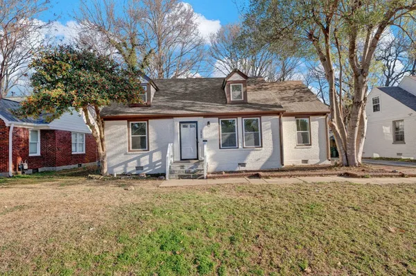 a view of a house with a patio and a yard