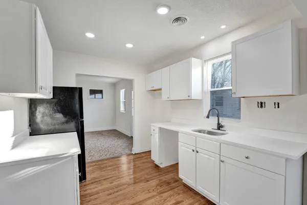 a kitchen with a sink a stove and cabinets