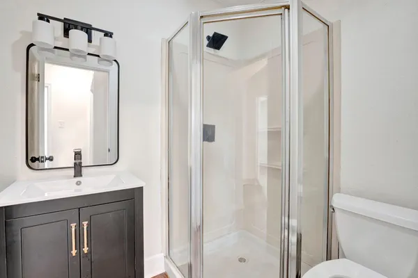 a bathroom with a shower sink and mirror