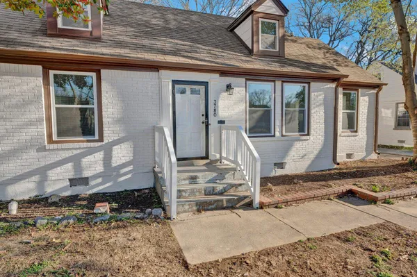 a front view of a house with a floor to ceiling windows and a rug