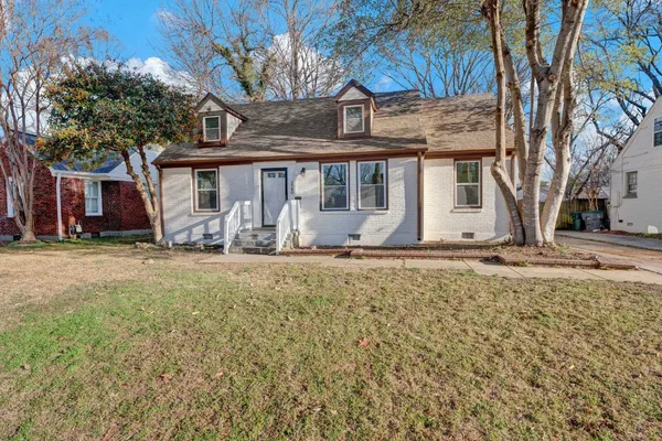 a front view of house with yard and trees around