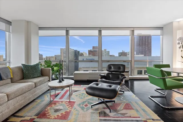 a living room with furniture fireplace and a large window