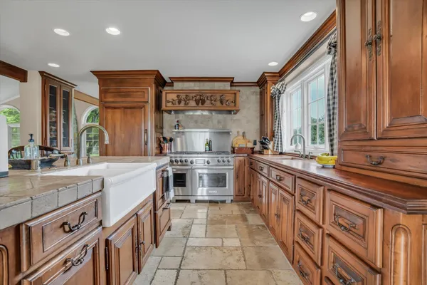 a large kitchen with stainless steel appliances a sink and cabinets