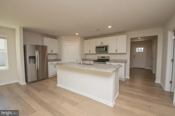 a kitchen with refrigerator cabinets and wooden floor