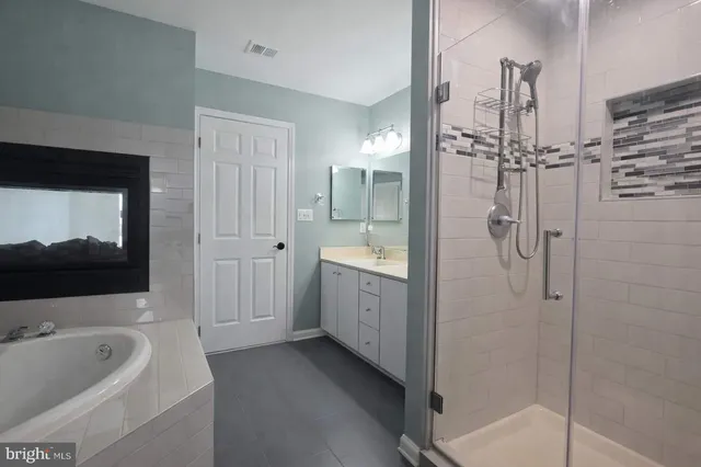 a bathroom with a tub a sink and mirror