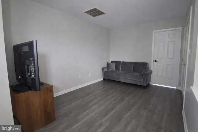 a living room with couch and a wooden floor