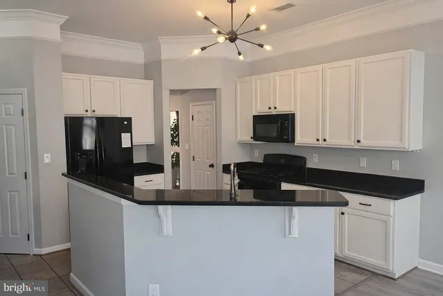 a kitchen with stainless steel appliances granite countertop a refrigerator a stove a microwave oven a sink with granite countertops and cabinets