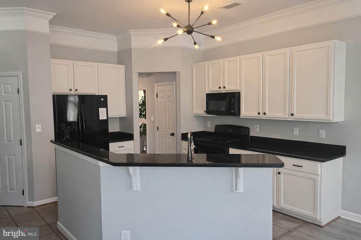 43068 Eustis Street Chantilly, VA 20152 - Photo 6 of 25 a kitchen with stainless steel appliances granite countertop a refrigerator a stove a microwave oven a sink with granite countertops and cabinets