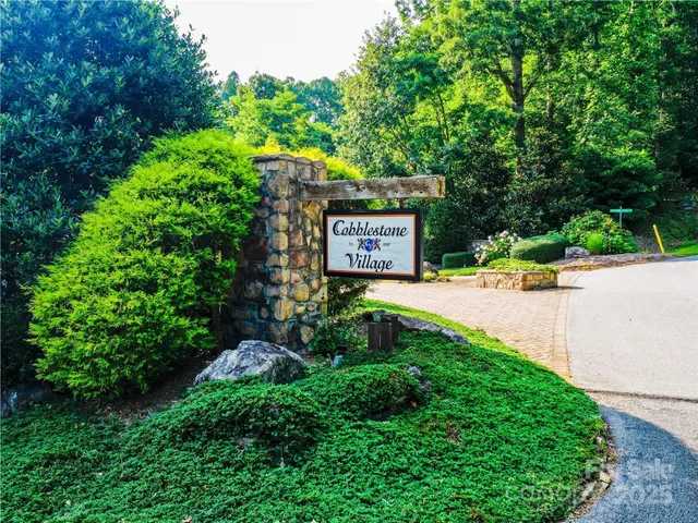 a sign that is sitting in the grass next to a road