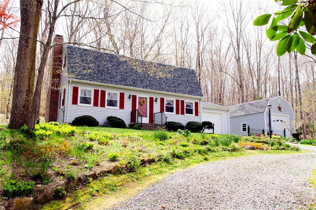 72 Hanover Versailles Road Sprague, CT 06330 - Photo 1 of 1 a front view of a house with a garden and trees