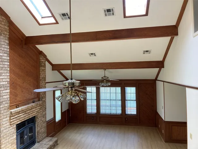an empty room with wooden floor closet and windows