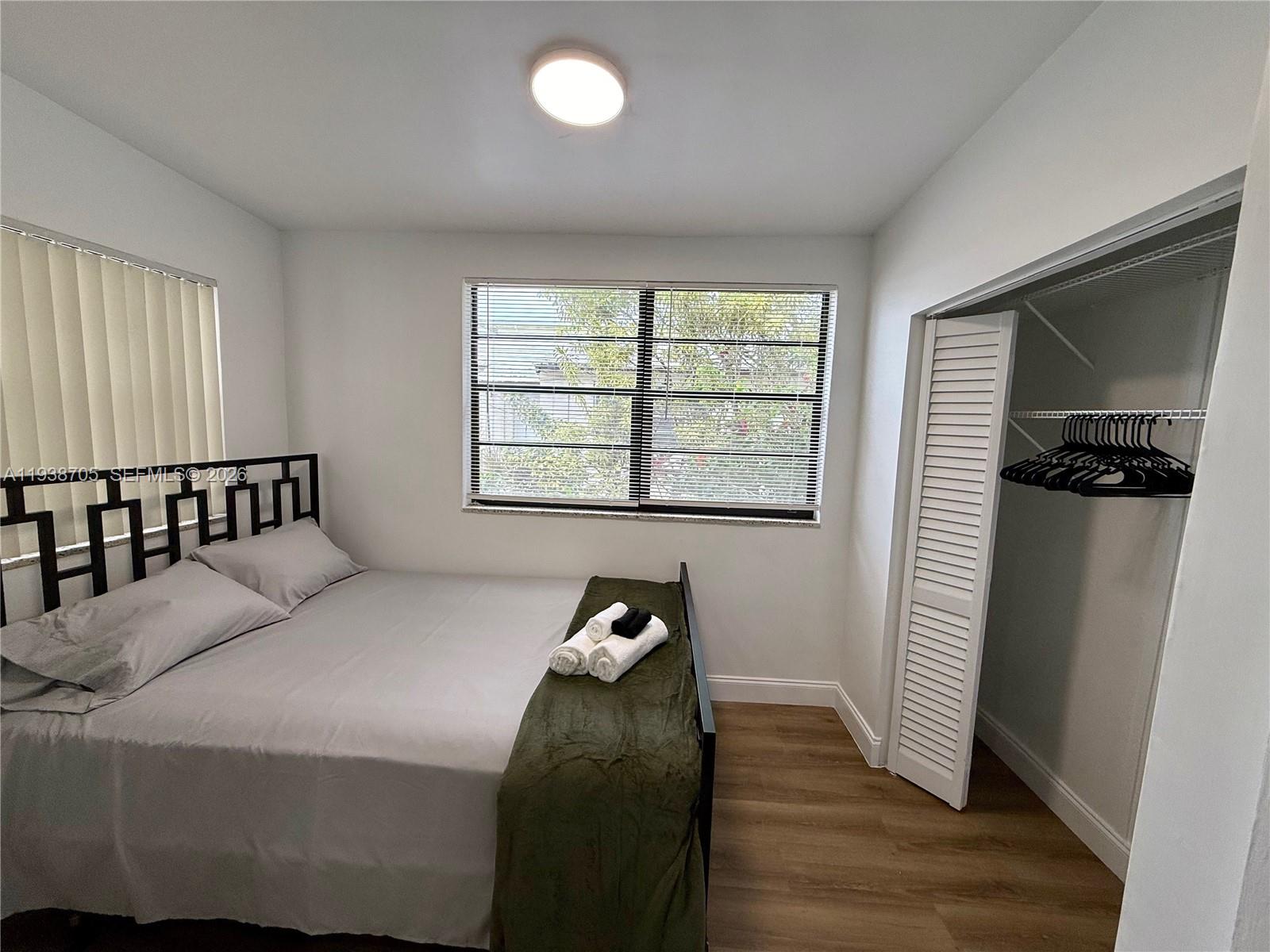 864 80th Street, Unit 1 Miami Beach, FL 33141 - Photo 11 of 13 a bedroom with a bed and wooden floor