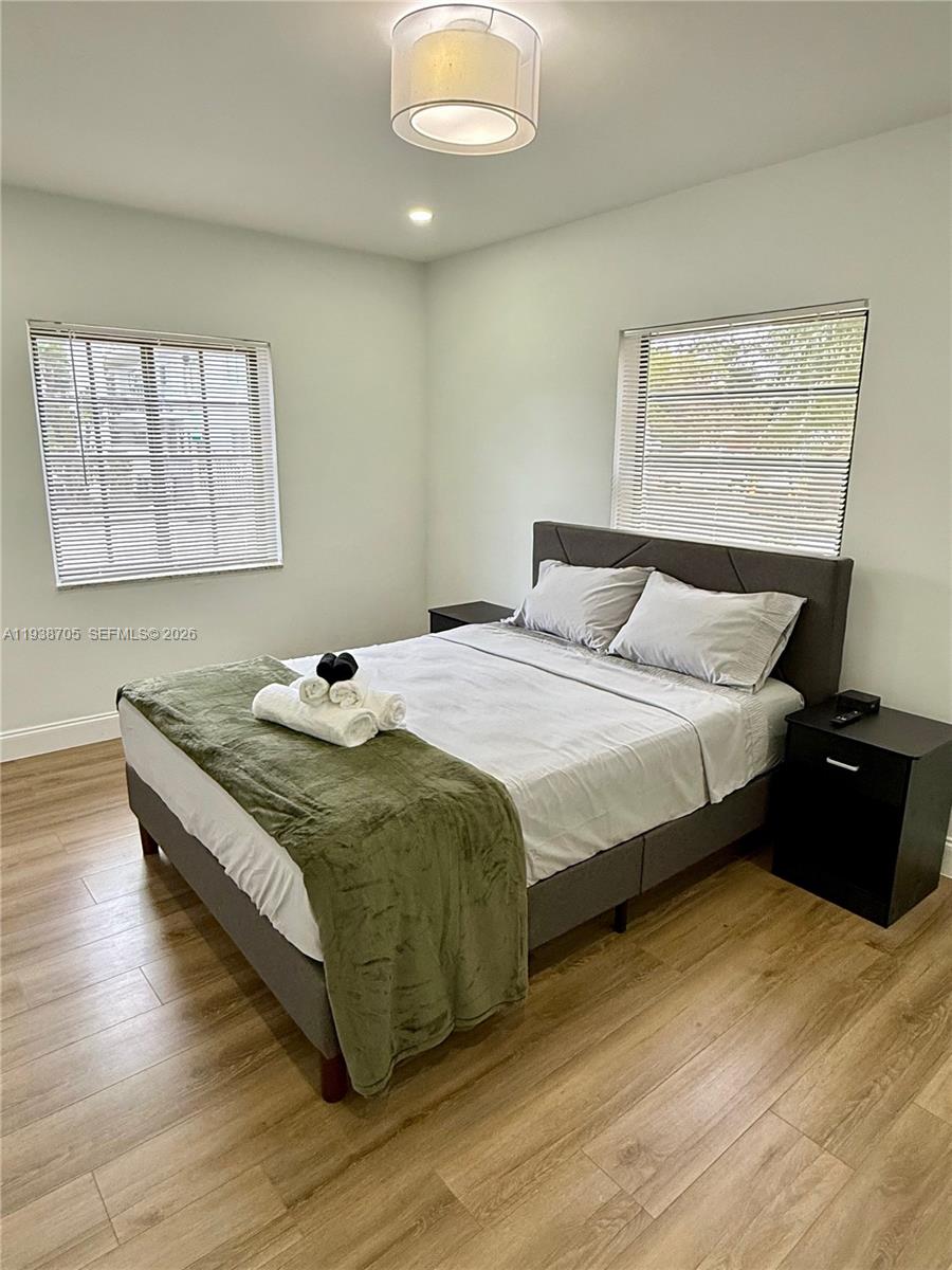 864 80th Street, Unit 1 Miami Beach, FL 33141 - Photo 8 of 13 a bedroom with a bed and wooden floor