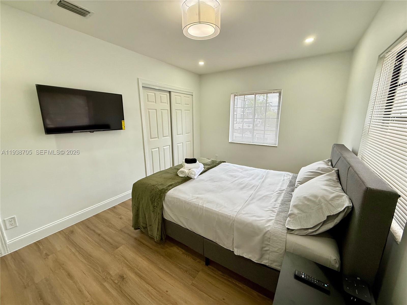 864 80th Street, Unit 1 Miami Beach, FL 33141 - Photo 9 of 13 a bedroom with a bed and a flat screen tv