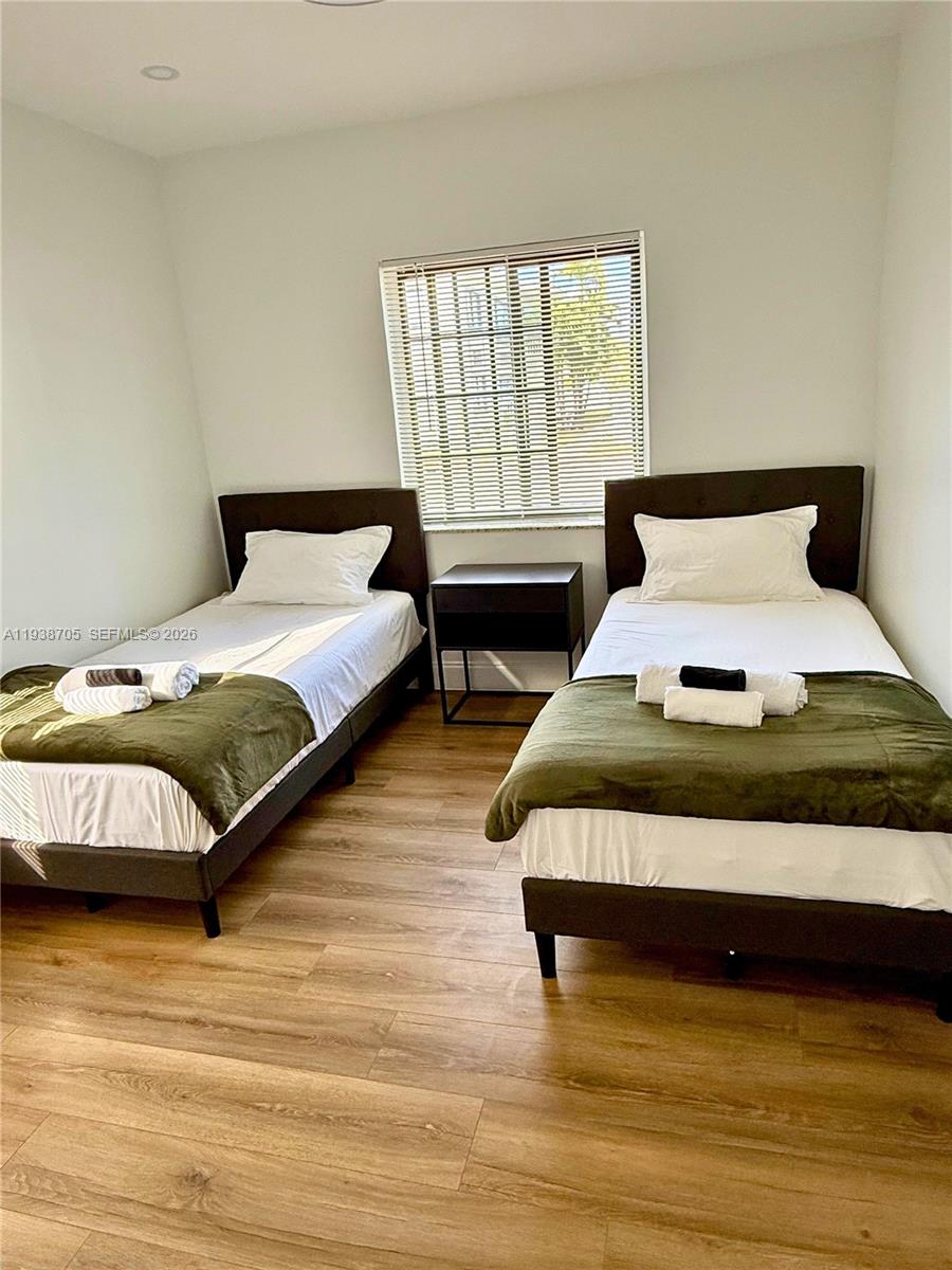 864 80th Street, Unit 1 Miami Beach, FL 33141 - Photo 10 of 13 a bedroom with a bed lamp and a window