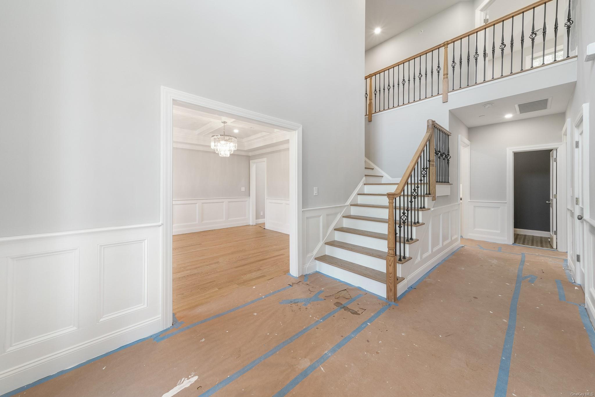 47 Laurel Lane Locust Valley, NY 11560 - Photo 4 of 39 Stairs featuring an inviting chandelier and ornamental molding