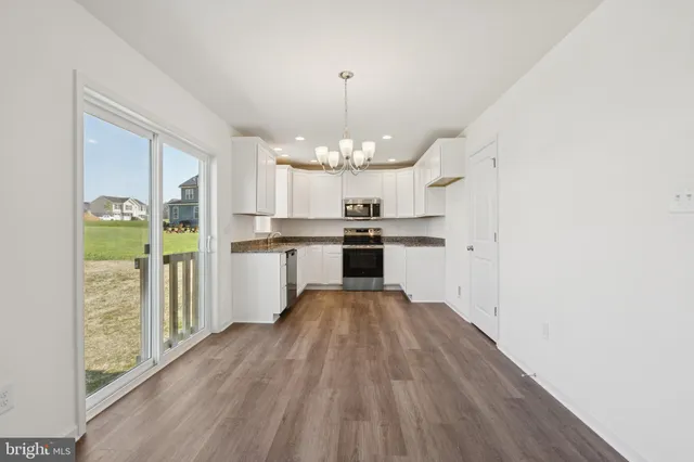 a view of a kitchen with wooden floor electronic appliances and window