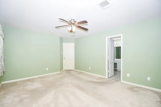 an empty room with closet and a chandelier fan