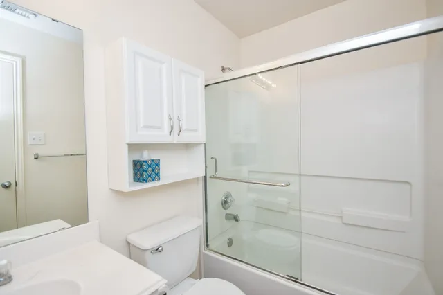 en empty room with windows and chandelier fan