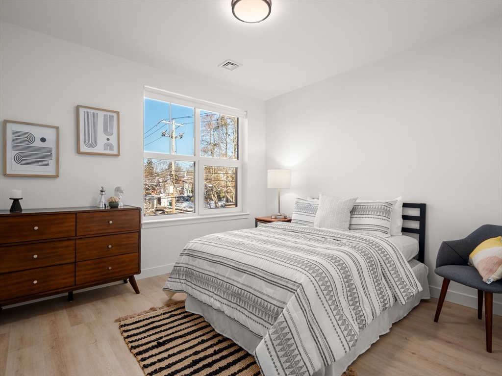 1151 Walnut Street, Unit 201 Newton, MA 02461 - Photo 11 of 31 a bedroom with a bed and wooden floor
