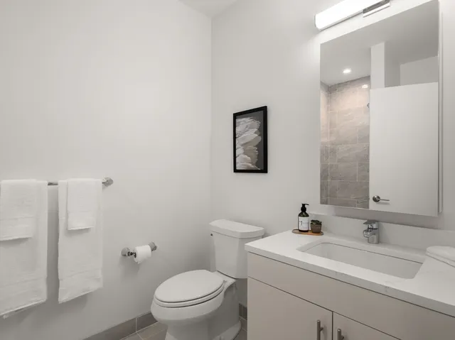 a bathroom with a toilet sink and mirror