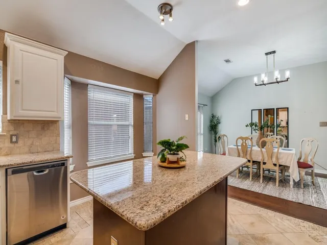 a dining hall with granite countertop kitchen island stainless steel appliances and a counter space